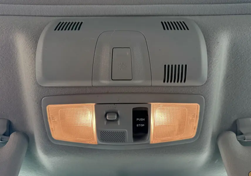 Plafonnier intérieur allumé avec interrupteurs, vue en gros plan du toit d’un Mitsubishi ASX gris de 2015.