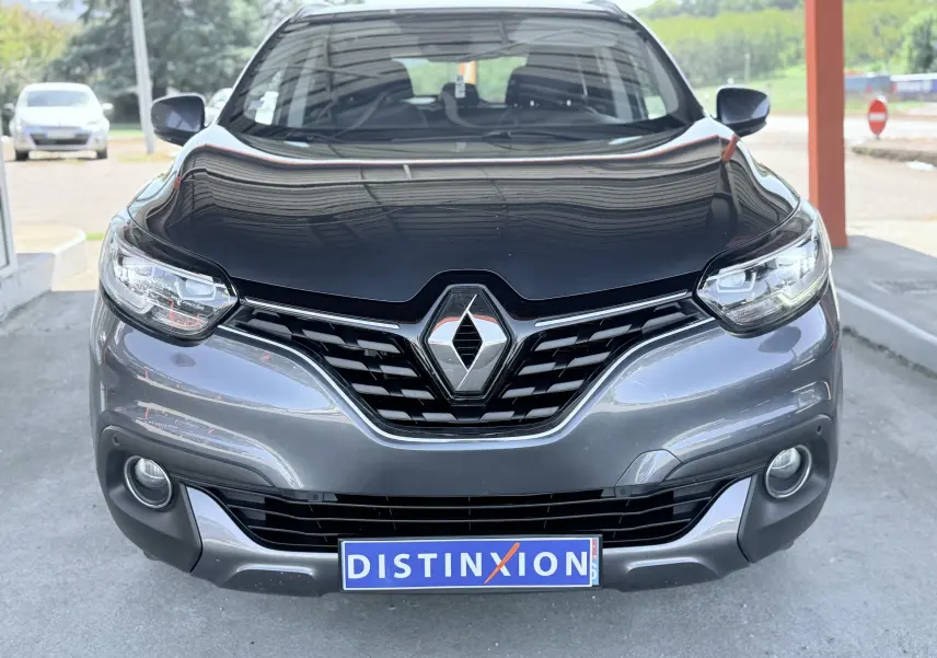 Vue avant d'un Renault Kadjar gris 2016 avec calandre noire et logo Renault bien visible.