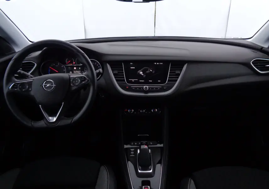 Intérieur noir de l'Opel Grandland X 1.6 Hybrid Turbo 2021, vue frontale sur tableau de bord et volant multifonction.