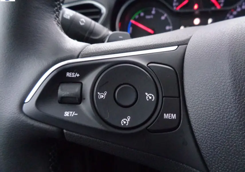 Gros plan sur les commandes de régulateur de vitesse au volant noir de l'Opel Grandland X hybride rechargeable 2021.