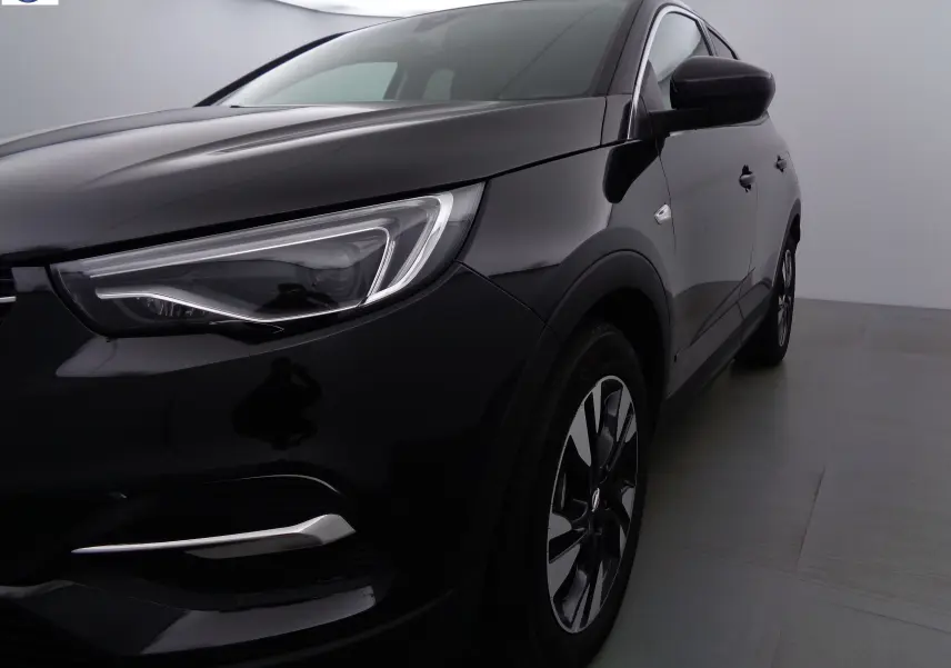 Vue 3/4 avant droit d'un Opel Grandland X noir métal avec phares LED et jantes alliage distinctives.