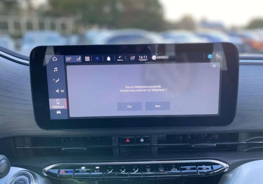 Écran tactile central affichant la connexion téléphone dans l'habitacle de la FIAT 500 électrique noire, vue intérieure frontale.