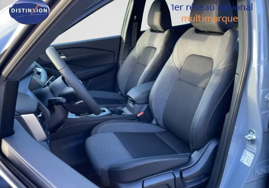 Vue intérieure côté conducteur du Nissan Qashqai 2025 gris argile, mettant en valeur les sièges tissu bi-ton et le tableau de bord.