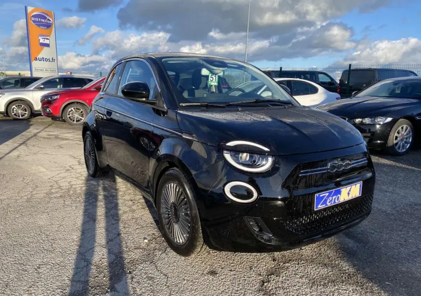 Fiat 500 électrique noire vue 3/4 avant droit, avec jantes spécifiques et toit vitré panoramique visible.