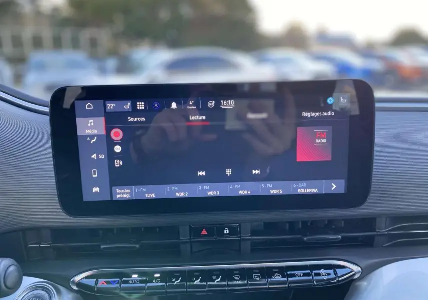 Écran tactile central du tableau de bord de la FIAT 500 électrique 2022 avec interface multimédia et climatisation automatique visible.