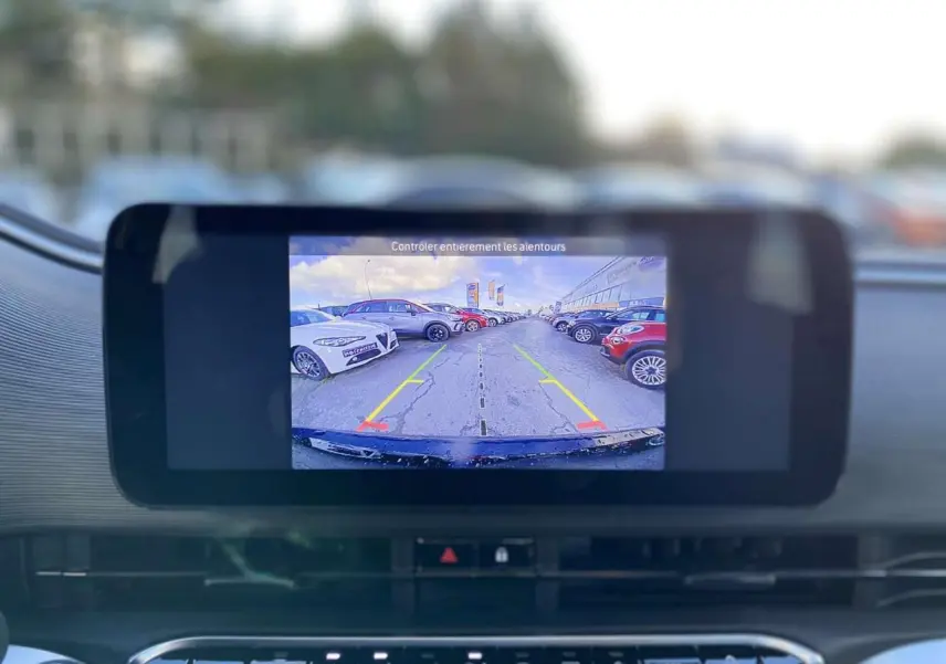 Écran de caméra de recul affichant un parking, vu depuis l’intérieur d’une FIAT 500 électrique noire.