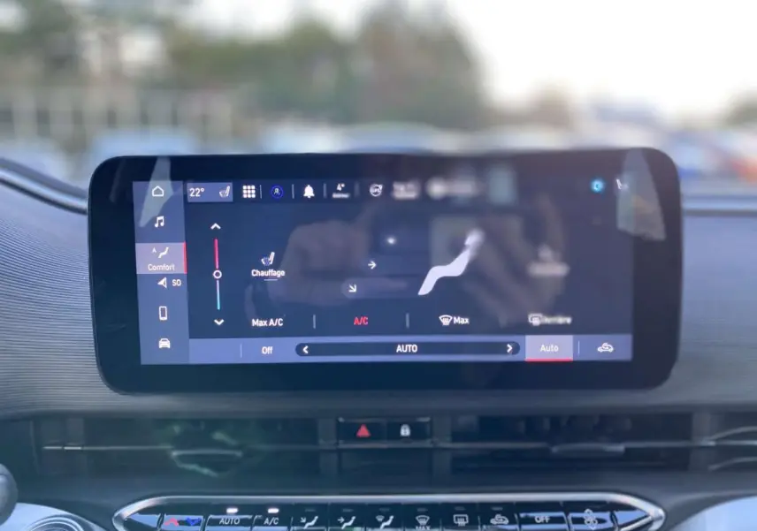Écran tactile central affichant le réglage automatique de la climatisation dans l'habitacle d'une Fiat 500 électrique noire.