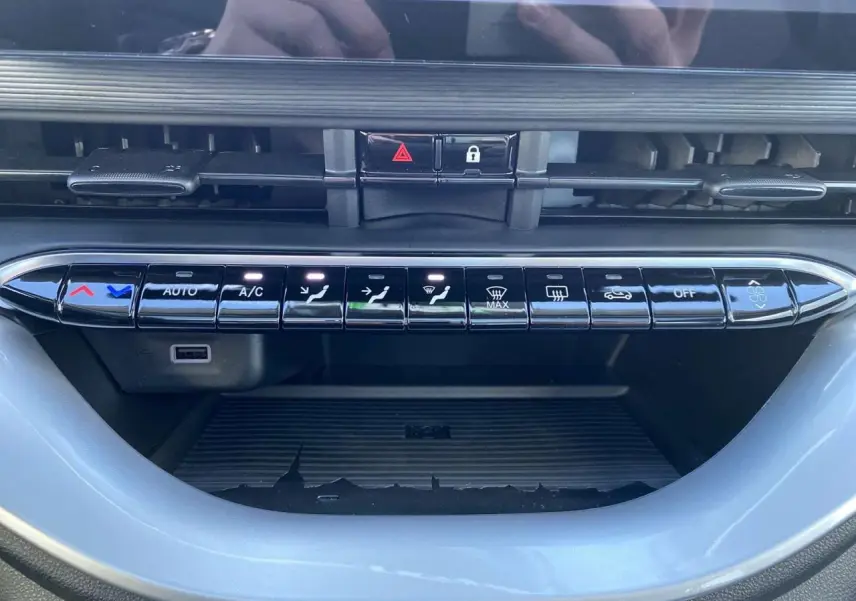 Gros plan sur la rangée de boutons de commande de climatisation noire dans le tableau de bord de la FIAT 500 électrique 2022.