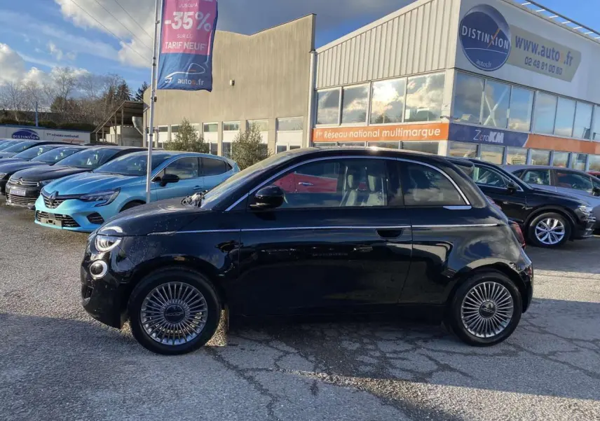 Profil côté gauche d'une FIAT 500 électrique noire 2022, avec jantes stylisées et poignées de portes discrètes.