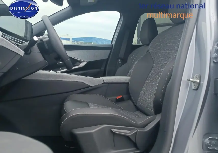 Vue intérieure côté conducteur du Peugeot 5008 Hybrid 145 allure gris artense, mettant en valeur le siège en tissu et cuir.