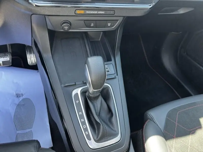 Vue rapprochée de la console centrale du Ford Puma blanc 2025, mettant en valeur le levier de boîte automatique et les commandes environnantes.