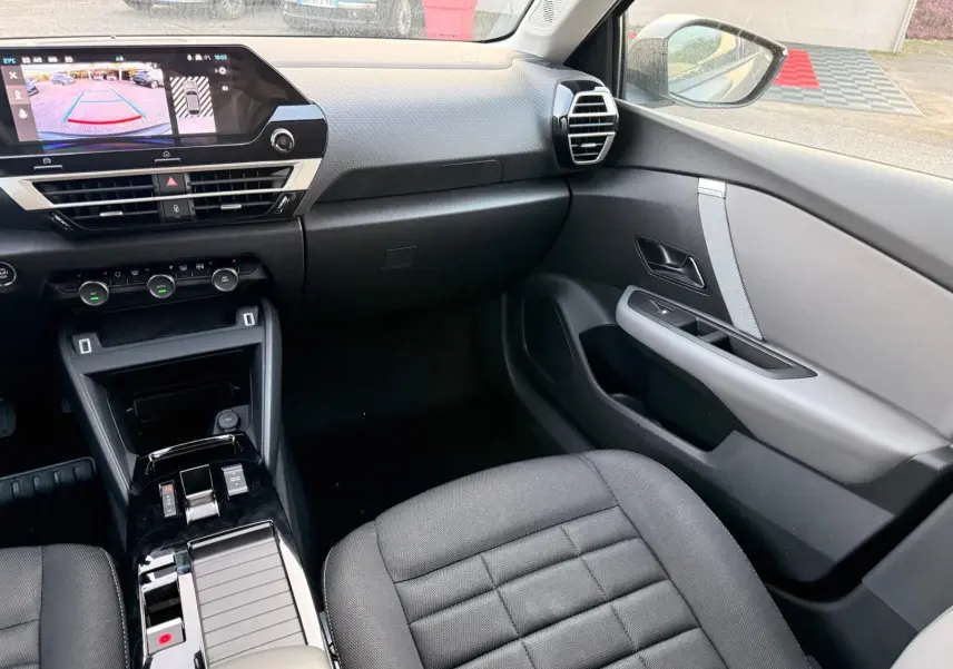 Intérieur côté passager de la Citroën C4 hybride gris Mercury 2025, avec tableau de bord moderne et écran tactile affichant la caméra de recul.