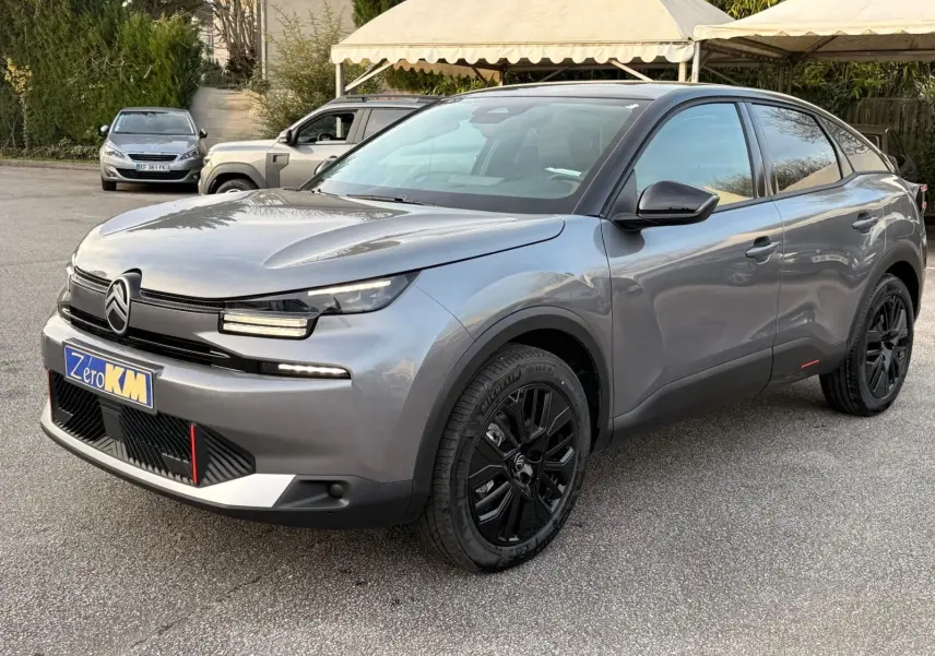 Citroën C4 hybride gris Mercury vue 3/4 avant droit avec jantes noires et signature lumineuse LED distinctive.