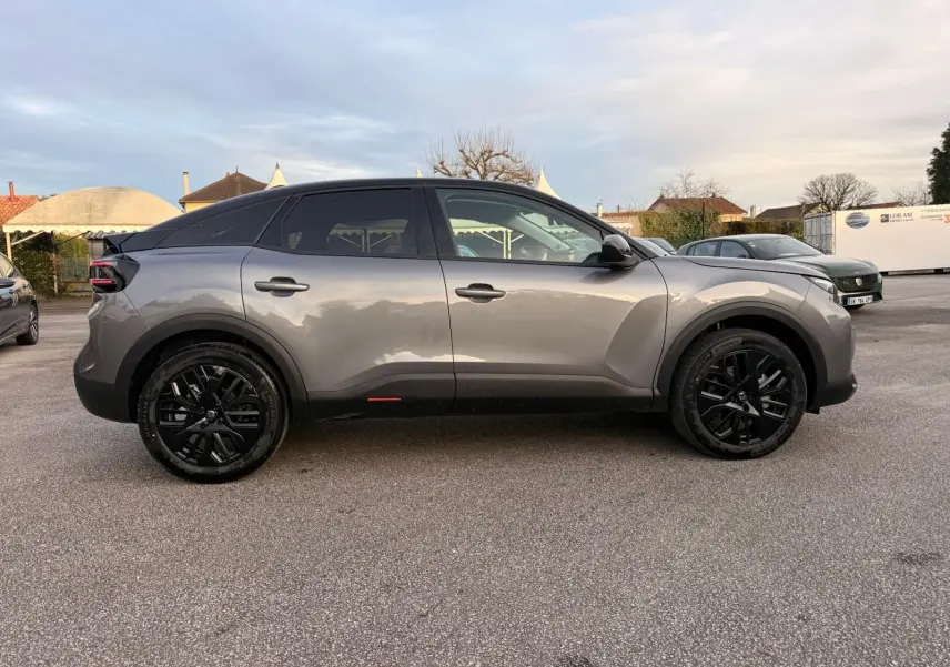 Vue de profil côté droit d'une Citroën C4 hybride 2025 gris Mercury avec toit noir et jantes noires.