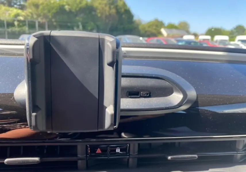 Support smartphone fixé sur la planche de bord noire de la Fiat 500 électrique blanche, vue rapprochée côté passager.