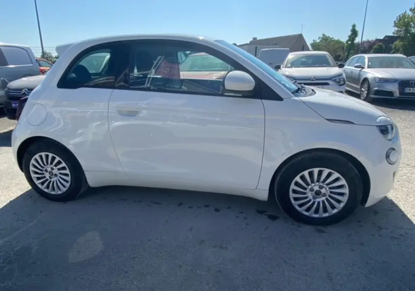 Profil côté gauche d'une FIAT 500 électrique blanche Ice White 2022 avec jantes alliage et peinture métallisée.