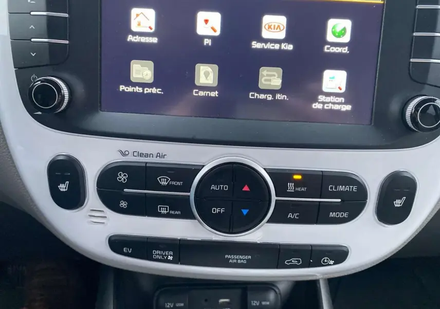 Gros plan sur la console centrale blanche avec écran tactile et commandes climatisation de la Kia Soul électrique noire 2016.