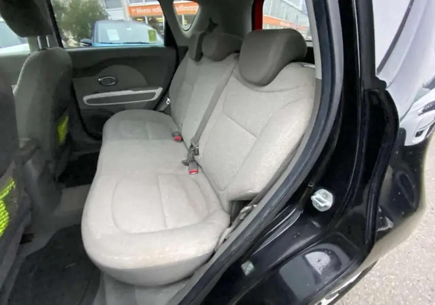 Vue intérieure côté gauche de la banquette arrière beige du KIA SOUL électrique noir avec porte ouverte.