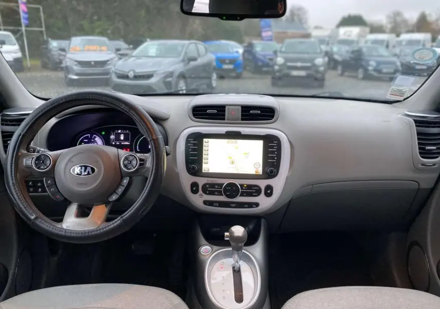 Intérieur du Kia Soul électrique 2016 vu de face, tableau de bord avec écran tactile et volant multifonction noir.