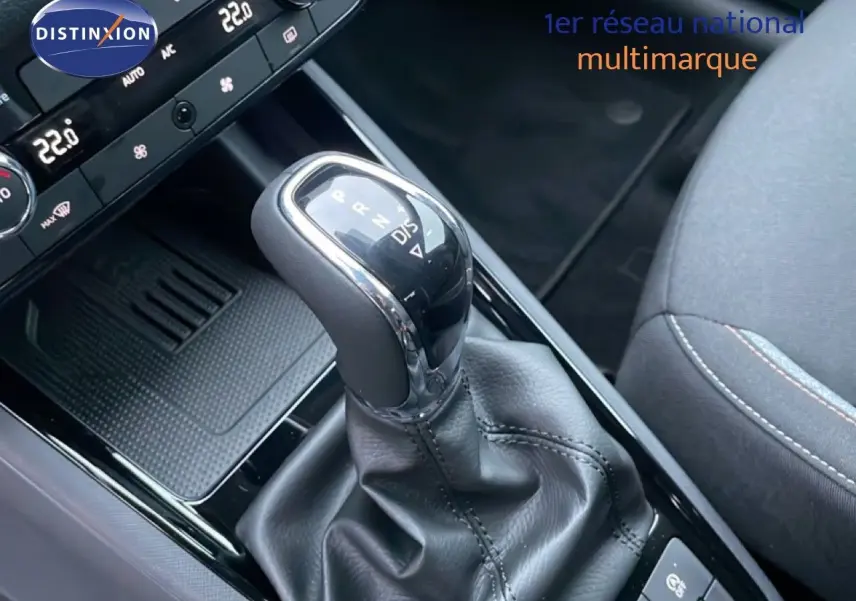 Gros plan sur la commande de boîte automatique du Skoda Kamiq gris graphite, avec console et siège tissu visibles.