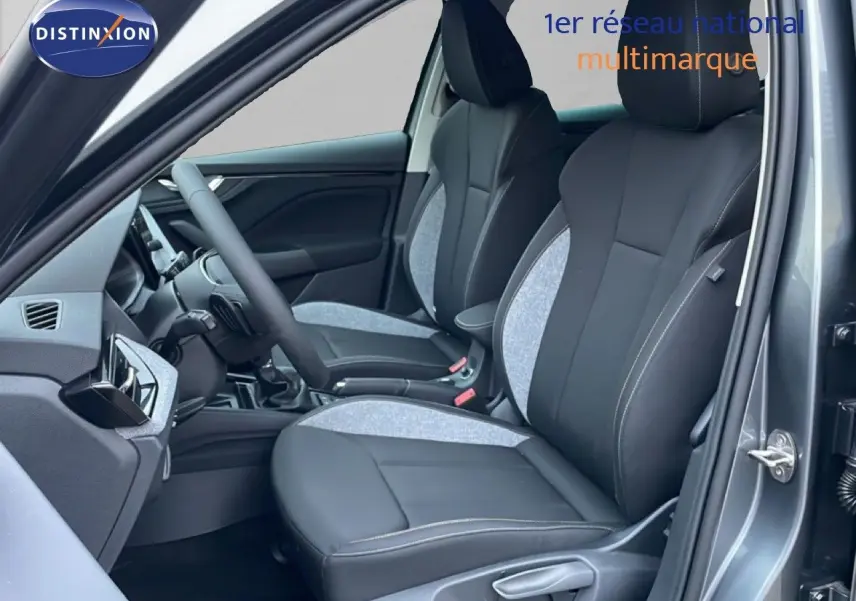 Vue intérieure côté conducteur du Skoda Kamiq 2025 gris graphite, sièges tissu et cuir bicolores avec surpiqûres contrastées.