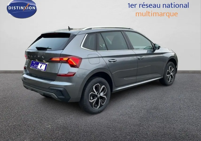 Vue 3/4 arrière droite d'un Skoda Kamiq gris graphite métal avec jantes alliage et feux arrière LED allumés.