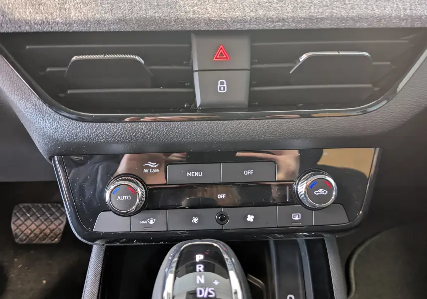 Vue rapprochée de la console centrale du Skoda Kamiq 2025 gris graphite, avec commandes climatisation et levier de boîte auto.