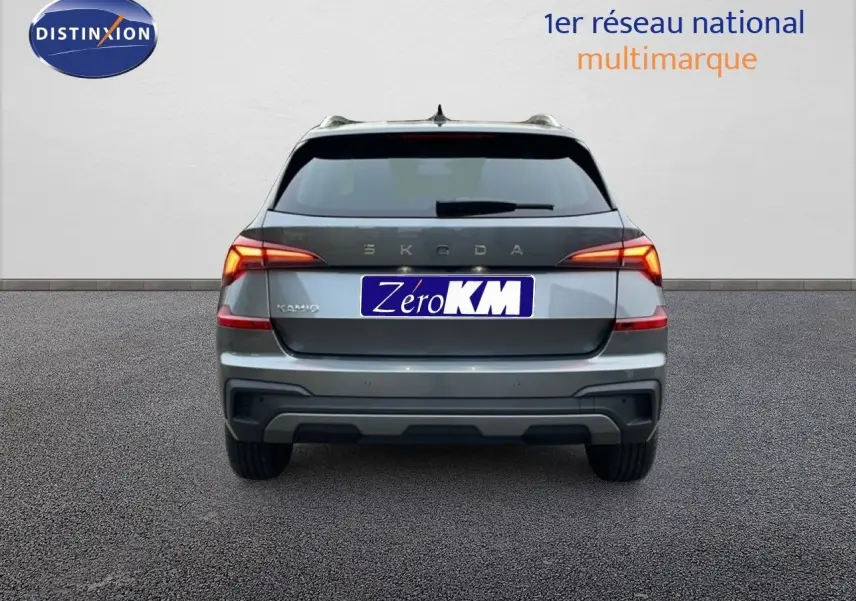 Vue arrière d'un Skoda Kamiq gris graphite métal 2025 avec feux LED allumés sur fond neutre.