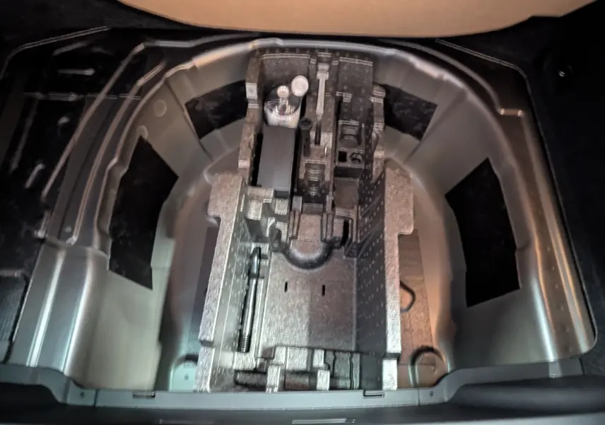 Vue plongeante sur le compartiment de rangement sous le coffre du Skoda Kamiq gris graphite, montrant l'emplacement pour outils.