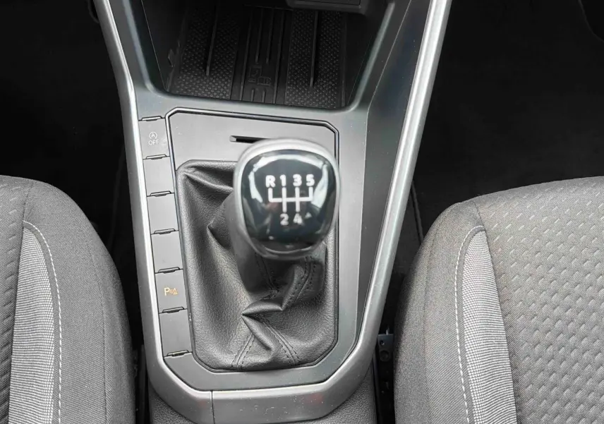 Vue rapprochée de la boîte manuelle 5 vitesses et des sièges gris de la Volkswagen Polo 2025.