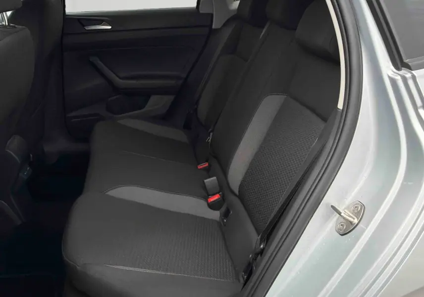 Vue côté droit de la banquette arrière noire et grise d'une Volkswagen Polo 2025 gris clair avec portière ouverte.