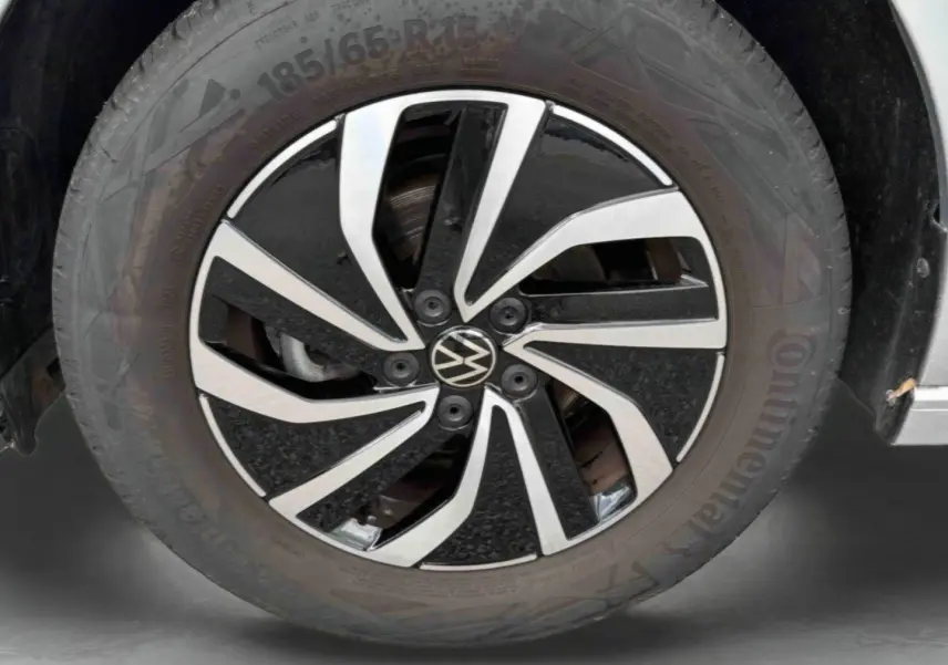 Gros plan sur la jante alliage 15 pouces Essex bicolore noir et argent de la Volkswagen Polo grise 2025.