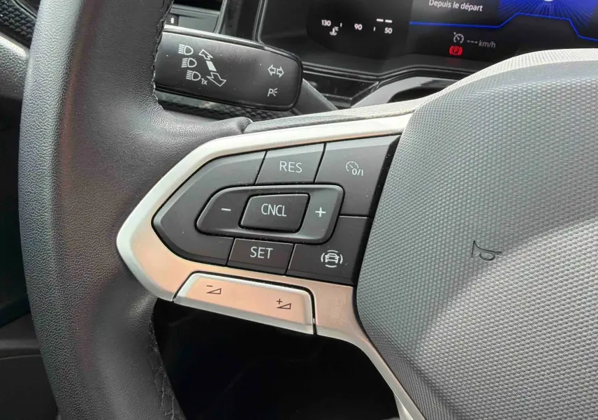Gros plan sur le volant multifonctions gris d’une Volkswagen Polo 2025 avec commandes de régulateur de vitesse.
