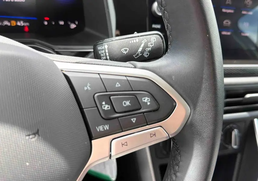 Gros plan sur le volant noir de la Volkswagen Polo 2025, côté gauche avec commandes multifonctions visibles.