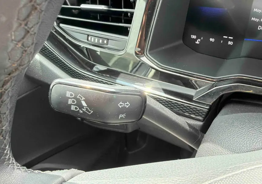 Détail du commodo gauche noir avec commandes d’éclairage sur le tableau de bord digital d’une Volkswagen Polo 2025.