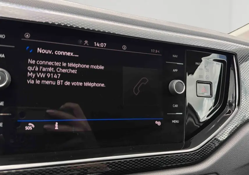 Vue rapprochée de l'écran tactile noir du système infotainment de la Volkswagen Polo grise 2025 avec commandes latérales.