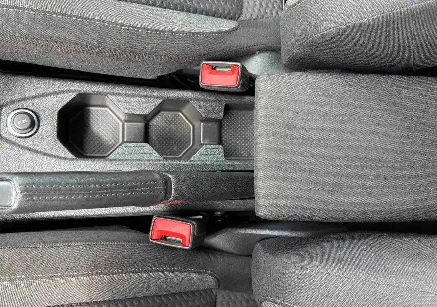 Vue plongeante sur la console centrale grise de la Volkswagen Polo 2025 avec frein à main et porte-gobelets.
