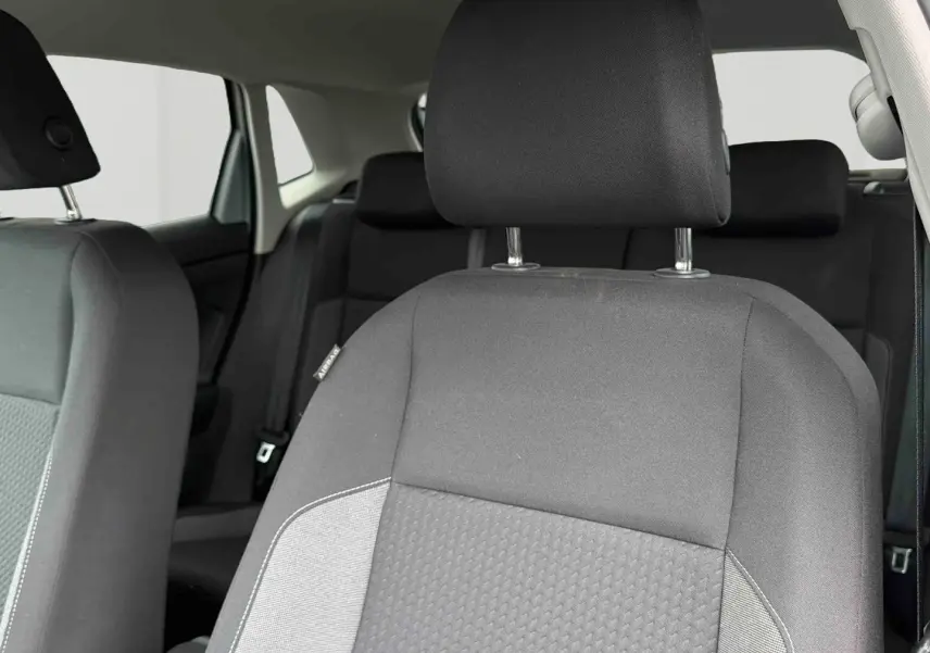 Gros plan sur le siège avant droit gris de la Volkswagen Polo 2025, tissu bi-ton avec appuie-tête intégré.