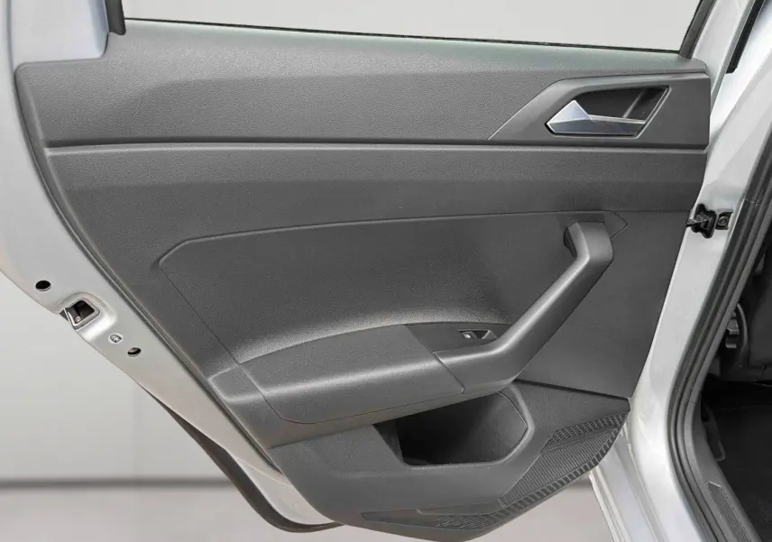 Vue rapprochée de la porte arrière droite grise d'une Volkswagen Polo 2025, avec poignée et commande de vitre visible.