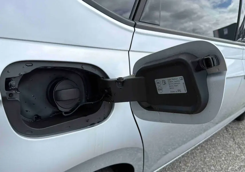 Vue rapprochée de la trappe à carburant ouverte côté gauche d’une Volkswagen Polo grise 2025.