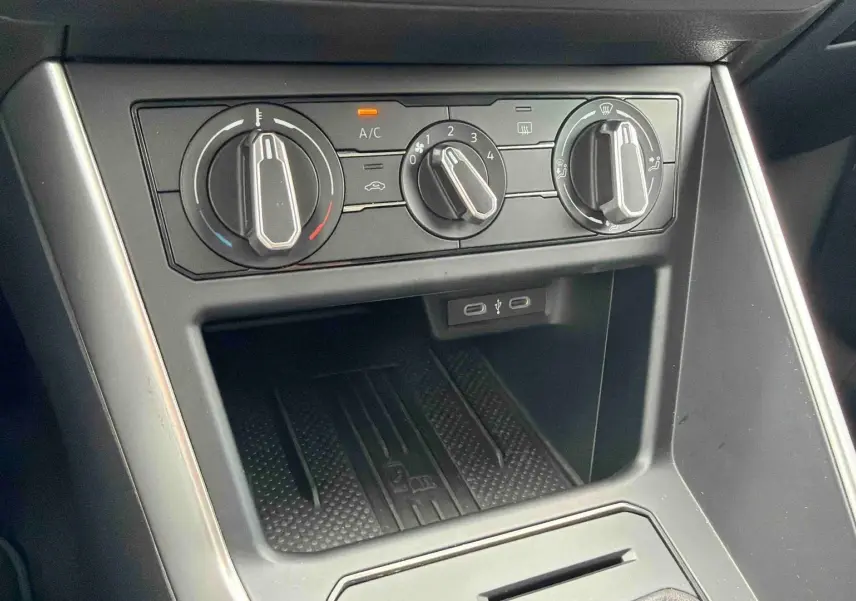 Console centrale vue de face avec commandes manuelles de climatisation et ports USB-C dans une Volkswagen Polo grise 2025.