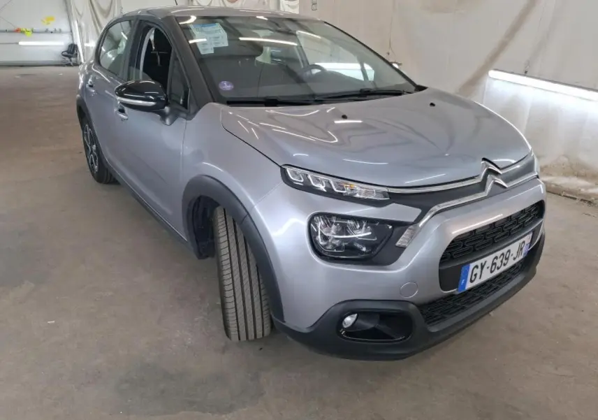 Citroën C3 gris foncé vue 3/4 avant droit, avec phares LED et calandre noire distinctive.