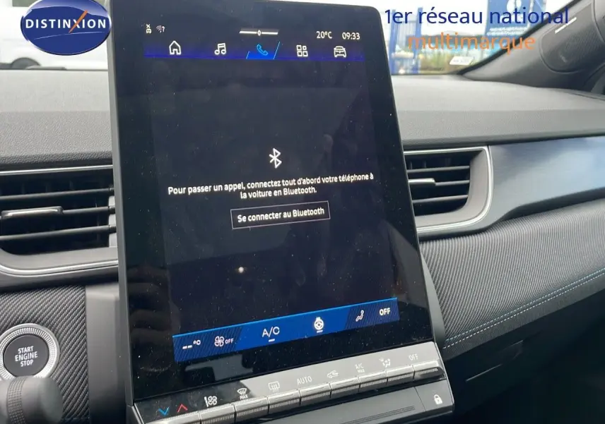 Vue intérieure centrée sur l’écran tactile du tableau de bord, avec détails du design gris et coutures bleues visibles.