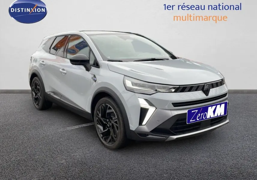 Renault Symbioz E-Tech gris Rafale métal, vue 3/4 avant droit avec jantes noires et signature lumineuse LED.