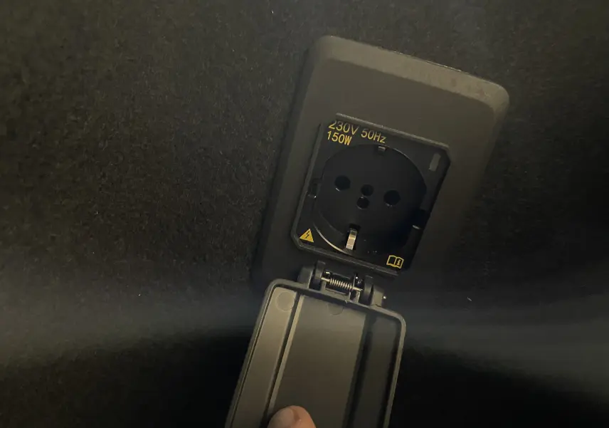 Prise électrique 230V 150W intégrée dans le coffre d'un CUPRA Formentor Noir Minuit 2023, détail intérieur.