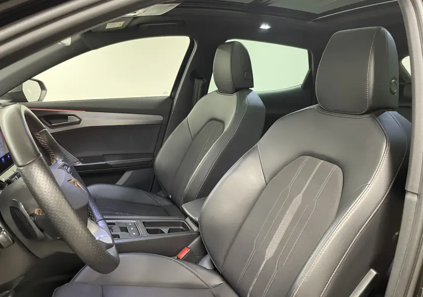 Intérieur du CUPRA Formentor 2023 vu côté gauche, sièges en cuir noir avec surpiqûres contrastantes et volant perforé.