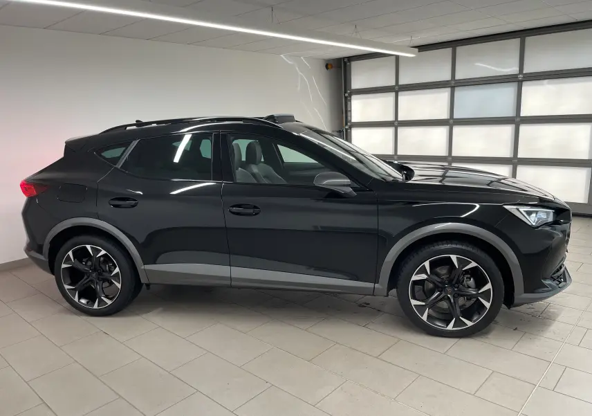 Vue de profil côté gauche d'un CUPRA Formentor 1.5 TSI 150 DSG7 VZ-LINE noir minuit avec jantes noires et grises.