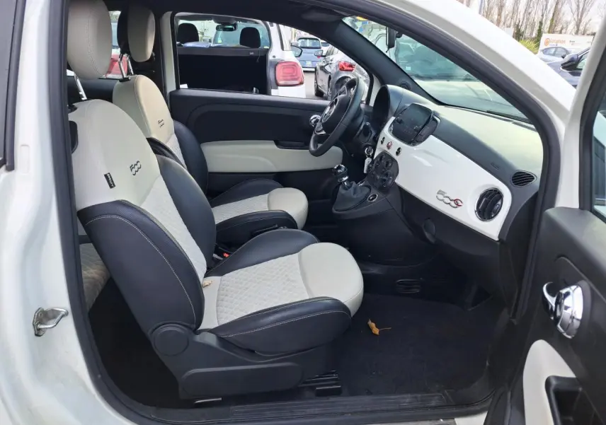 Vue côté gauche de l'intérieur blanc et noir du Fiat 500 Cabriolet 2021 avec tableau de bord épuré et logo 500C.