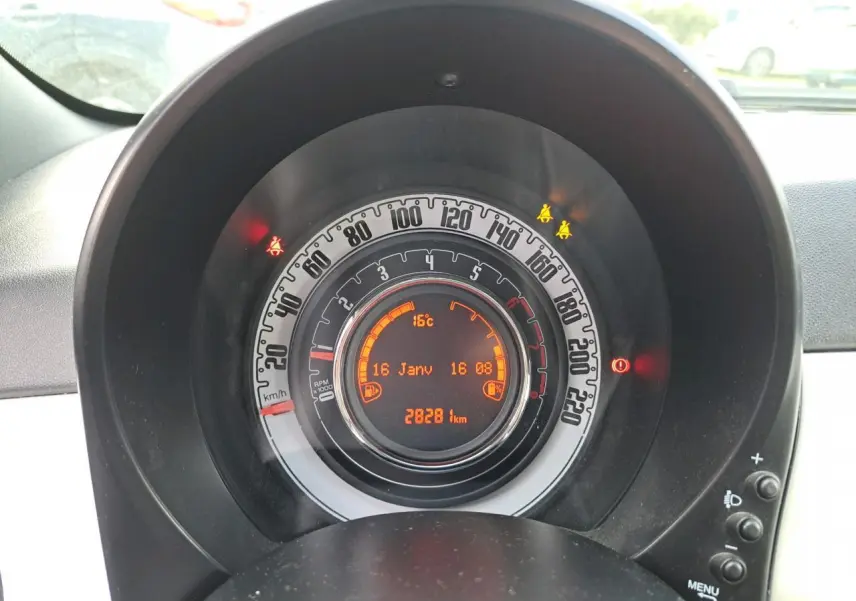 Gros plan sur le tableau de bord circulaire de la Fiat 500 Cabriolet blanche, affichant vitesse, température et kilométrage.