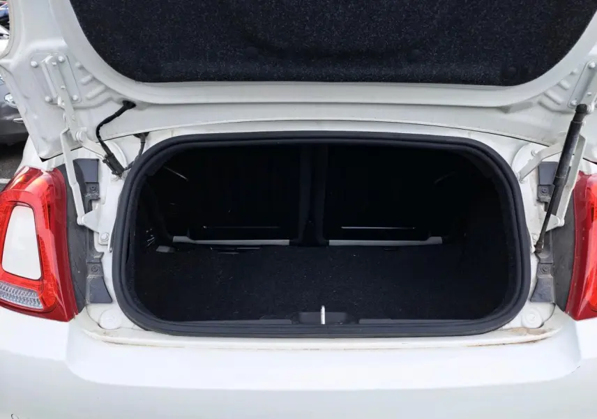 Coffre ouvert vu de l'arrière d'une Fiat 500 Cabriolet blanche de 2021, montrant l'espace de chargement vide.